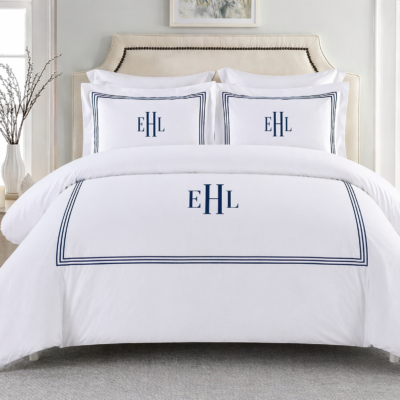 Personalized embroidered border duvet cover set with matching pillow shams styled on a bed