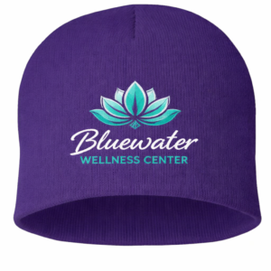 SPOT8 purple knit beanie embroidered with Bluewater Wellness Center logo for branded apparel, business uniforms, and promotional wear